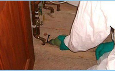 Technician treating gaps around plumbing pipes to keep bugs out of a Burlington home in summer
